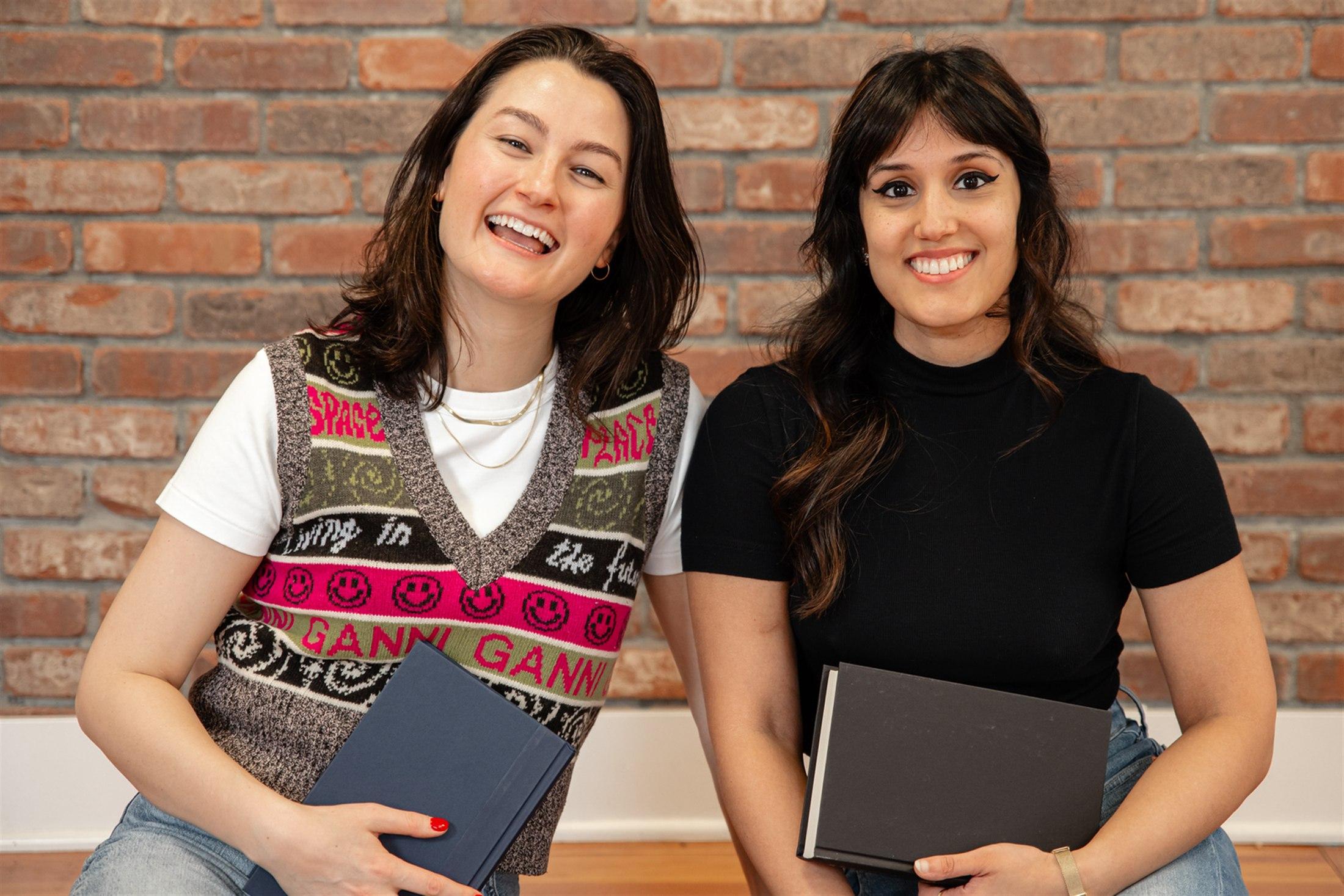 Grace and Honey smiling together while holding books