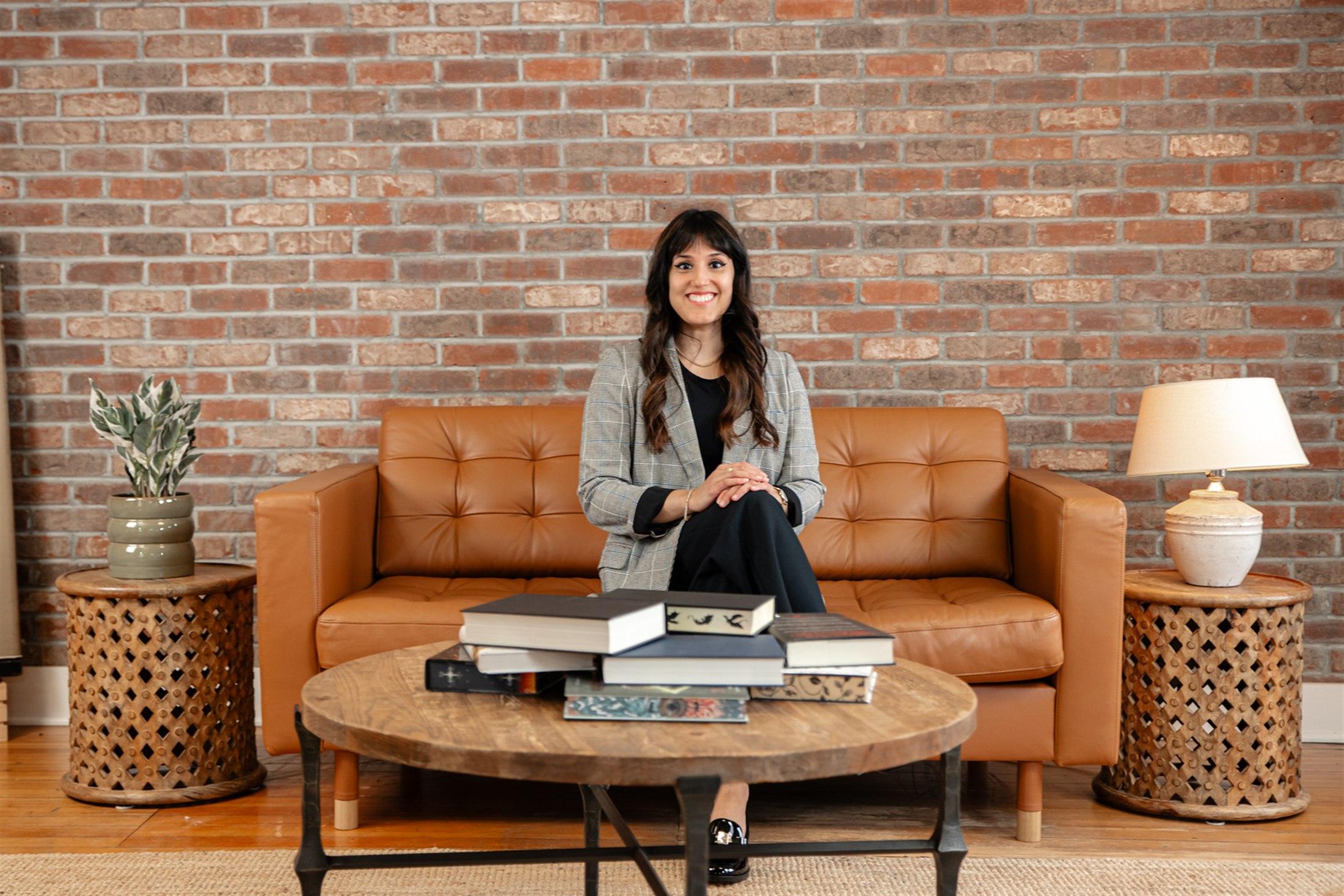 Honey Chawla seated in a reading room with a table of books